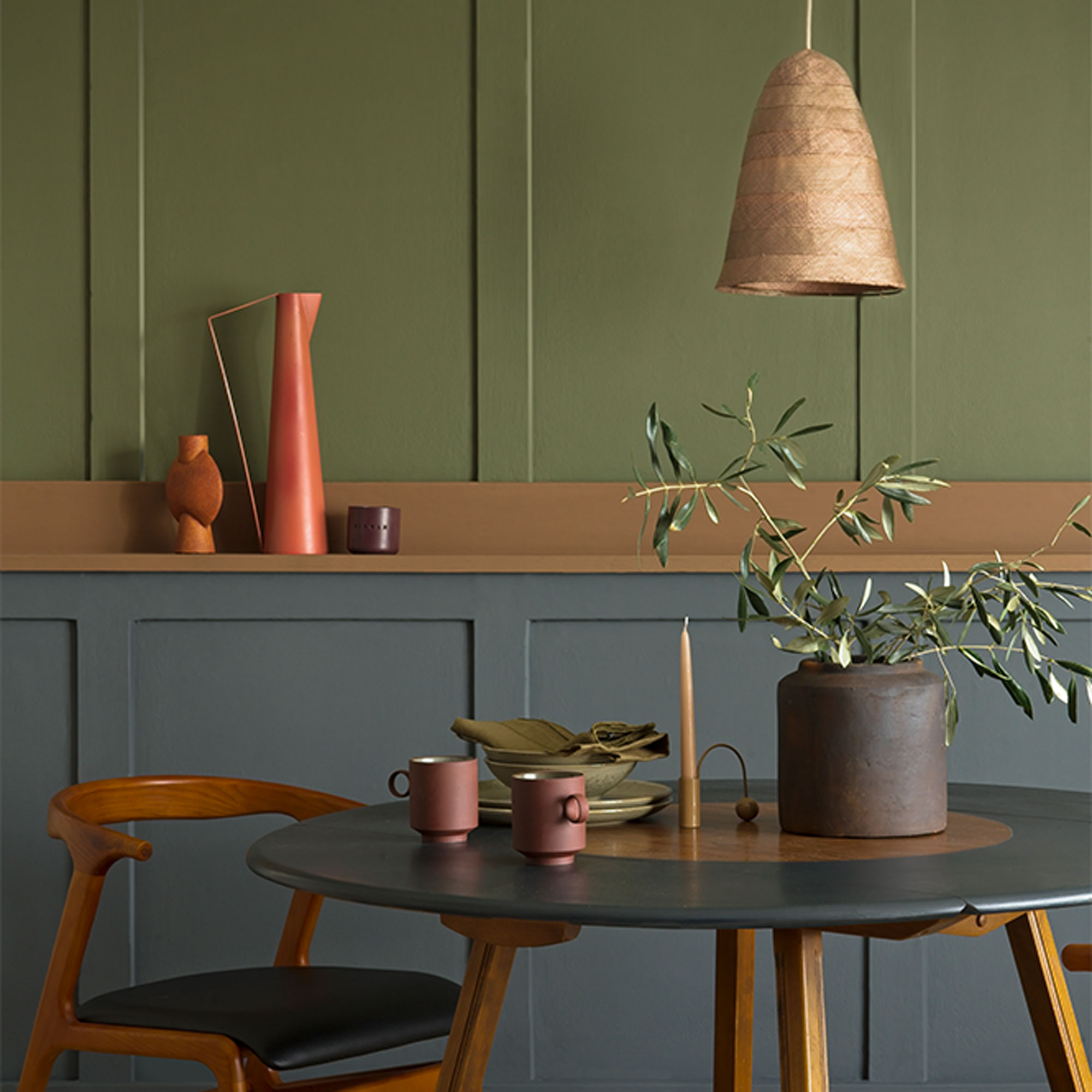painted panelling in grey and green with round dining table
