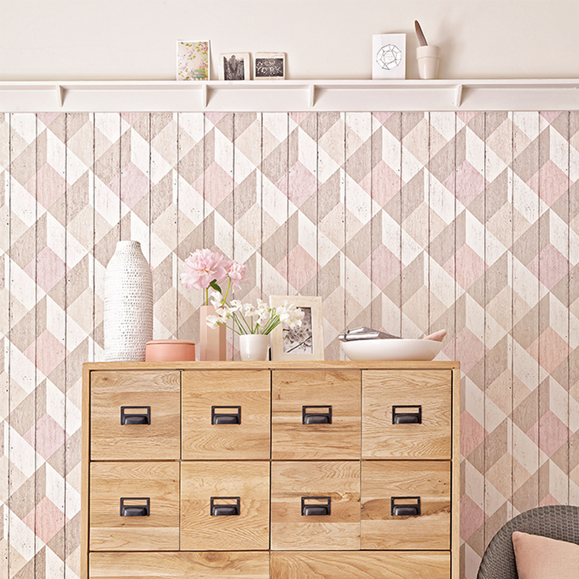pink and taupe wallpaper with wooden chest of drawers