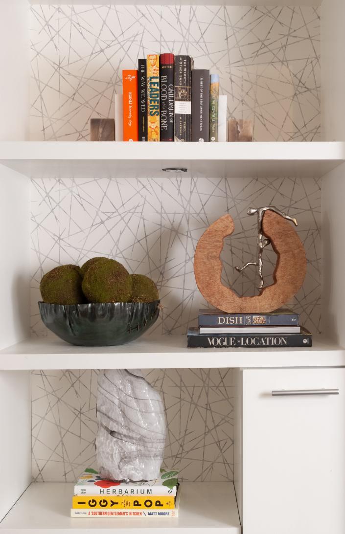 Graphic wallpaper can make a bookshelf pop, as seen in this Interior Design by S&amp;S project.