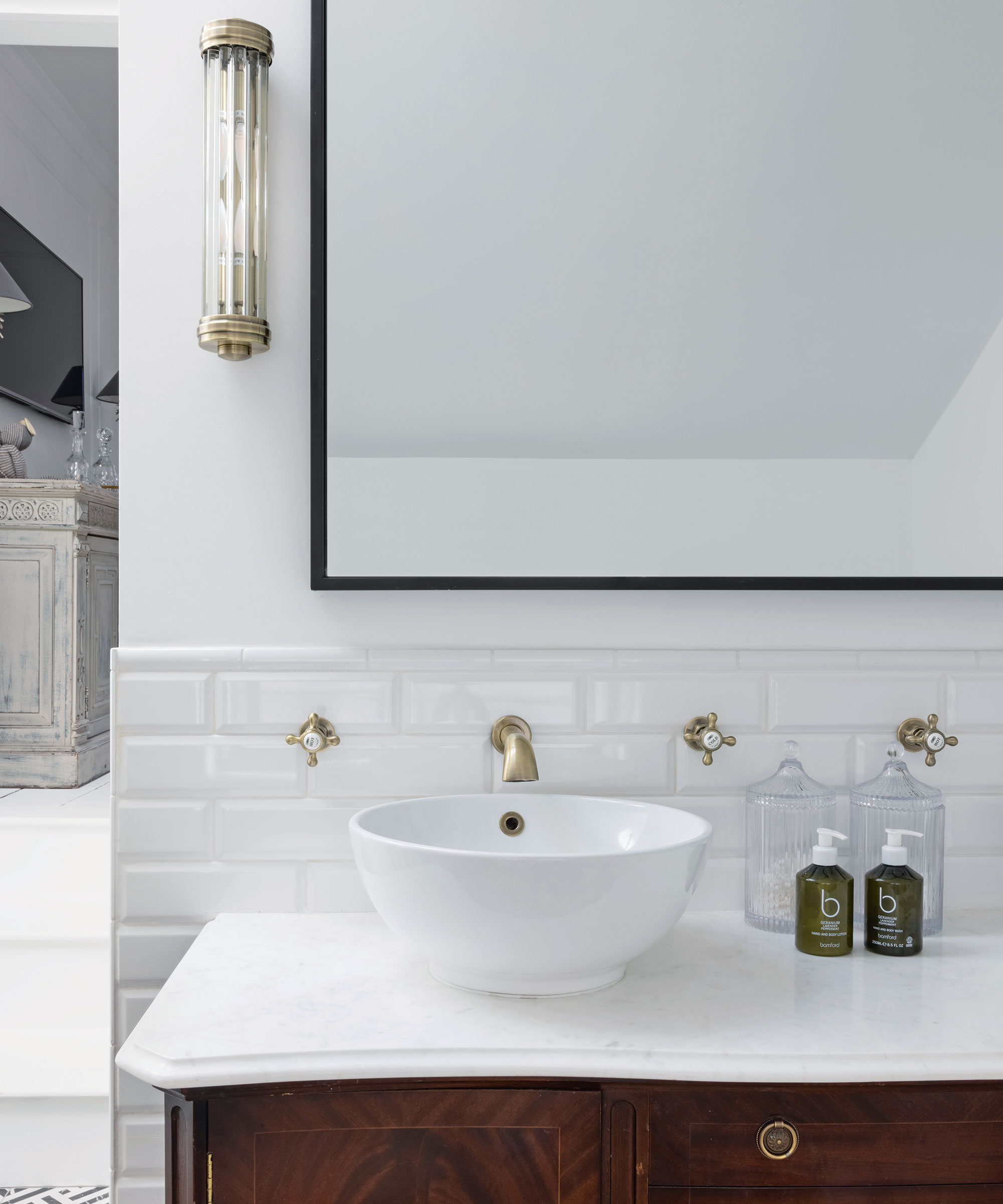 WHite vanity unit with large mirror hung on wall above